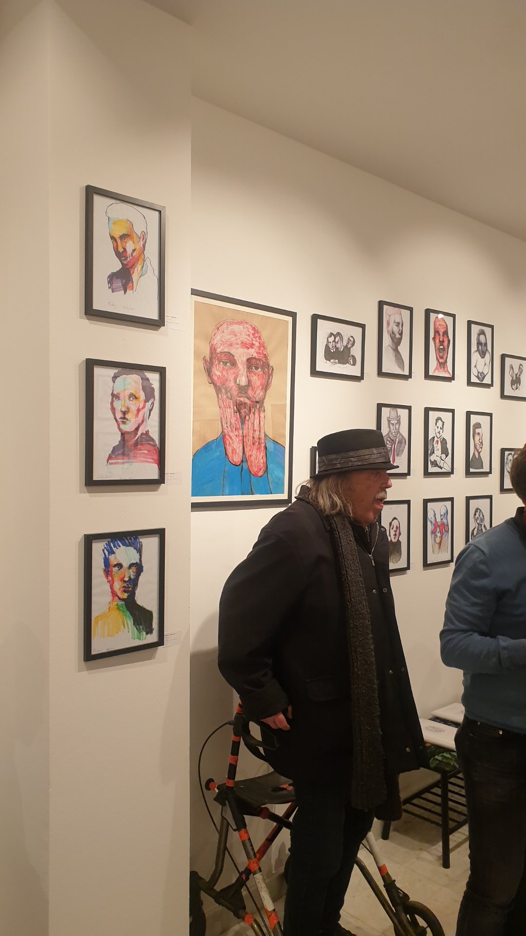 Vue de l'accrochage de « The Working Dead » : les portraits de Renier Semidey au stylo-bille, à l'encre et au marqueur, encadrés de noir, chez Zaza from Brussels.

Trois portraits colorés en colonne, une grande tête rose aux mains collées au visage, puis une grille de petits dessins en noir et blanc : le mur se lit comme un trombinoscope d'entreprise qui aurait mal tourné. Un visiteur au chapeau prend le temps d'en faire le tour.

« The Working Dead » de Renier Semidey, jusqu'au 15 novembre 2026 chez Zaza from Brussels, rue Blaes 122, 1000 Bruxelles (Marolles). Le mercredi de 11h à 18h, du jeudi au dimanche de 11h à 19h. Entrée libre.

Voir les liens utiles en bas de la description.

🔗 Pour aller plus loin et soutenir l'art local :
L'exposition « The Working Dead » de Renier Semidey : https://dropmuse.art/evenement/the-working-dead-renier-semidey-zazafrombrussels-bruxelles-a9c827
Renier Semidey sur Instagram : https://www.instagram.com/renier_del_mediodia/
La fiche acteur culturel de Zaza from Brussels : https://dropmuse.art/acteur-culturel/zazafrombrussels
Le site de la galerie : https://zazafrombrussels.com/
Suivre la galerie sur Instagram : https://www.instagram.com/zazafrombrussels/
La galerie sur Facebook : https://www.facebook.com/GalerieZazafromBrussels/
Retrouvez toute l'actualité culturelle sur DROPMUSE : https://dropmuse.art/