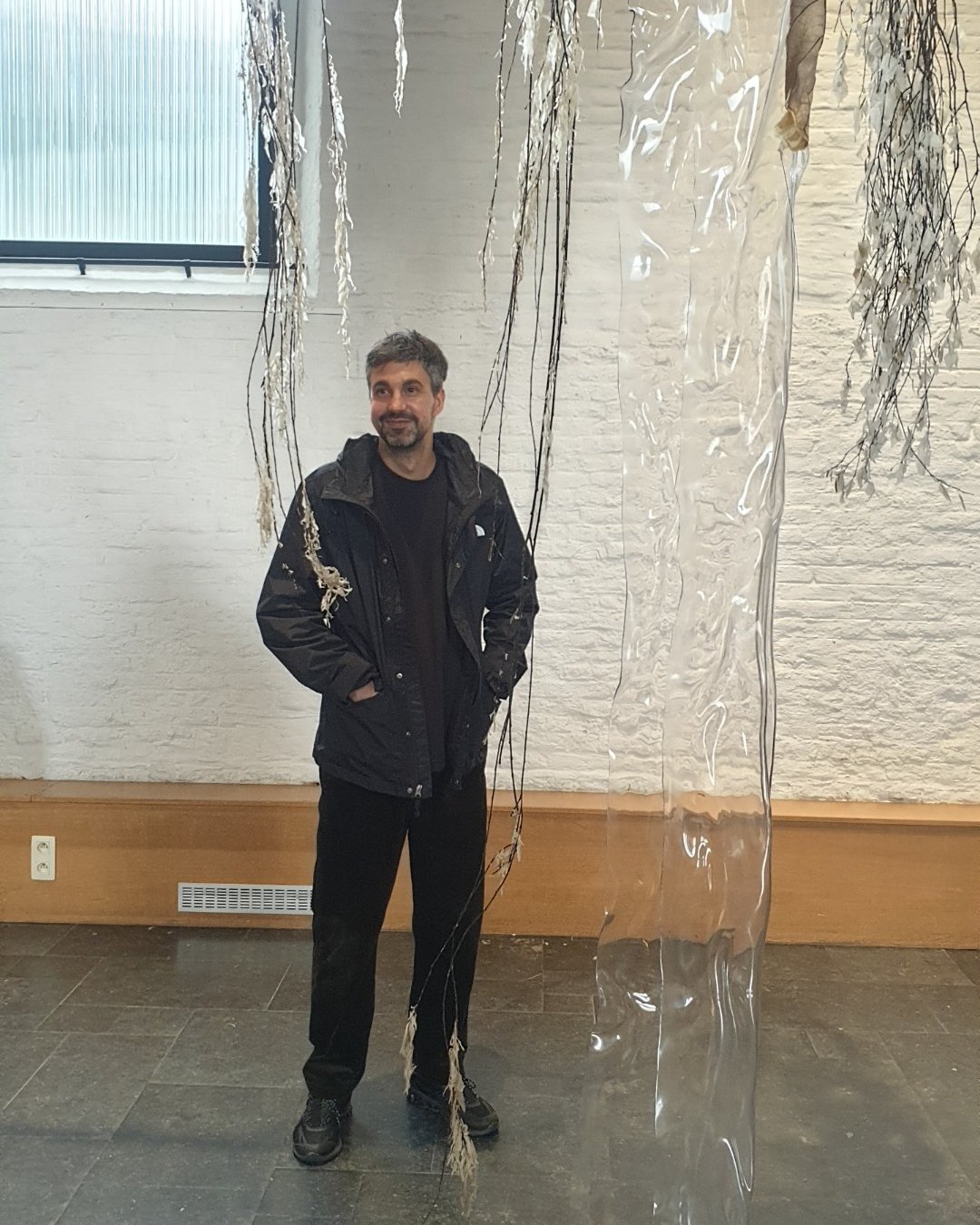 "La pratique artistique de Luca Vanello repose sur une sensibilité aux matériaux et aux processus, explorant les relations hybrides entre l'humain et le non-humain, l'écologie et les notions post-humaines de bien-être. Ses sculptures intègrent souvent de la matière végétale issue de jardins thérapeutiques, dont la chlorophylle a été extraite, formant ainsi des éléments fragiles et fantomatiques au sein d'installations immersives. Travaillant à la fois avec des matériaux organiques et synthétiques, Vanello crée des environnements poétiques et riches en matières qui estompent les frontières entre nature et technologie, attirant l'attention sur les conditions de vulnérabilité communes aux humains, aux non-humains et aux machines."

Photographie — Exposition Landslide à la Chapelle de Boondael : Art et scénographie à Ixelles, Centre d'Art de la Chapelle de Boondael