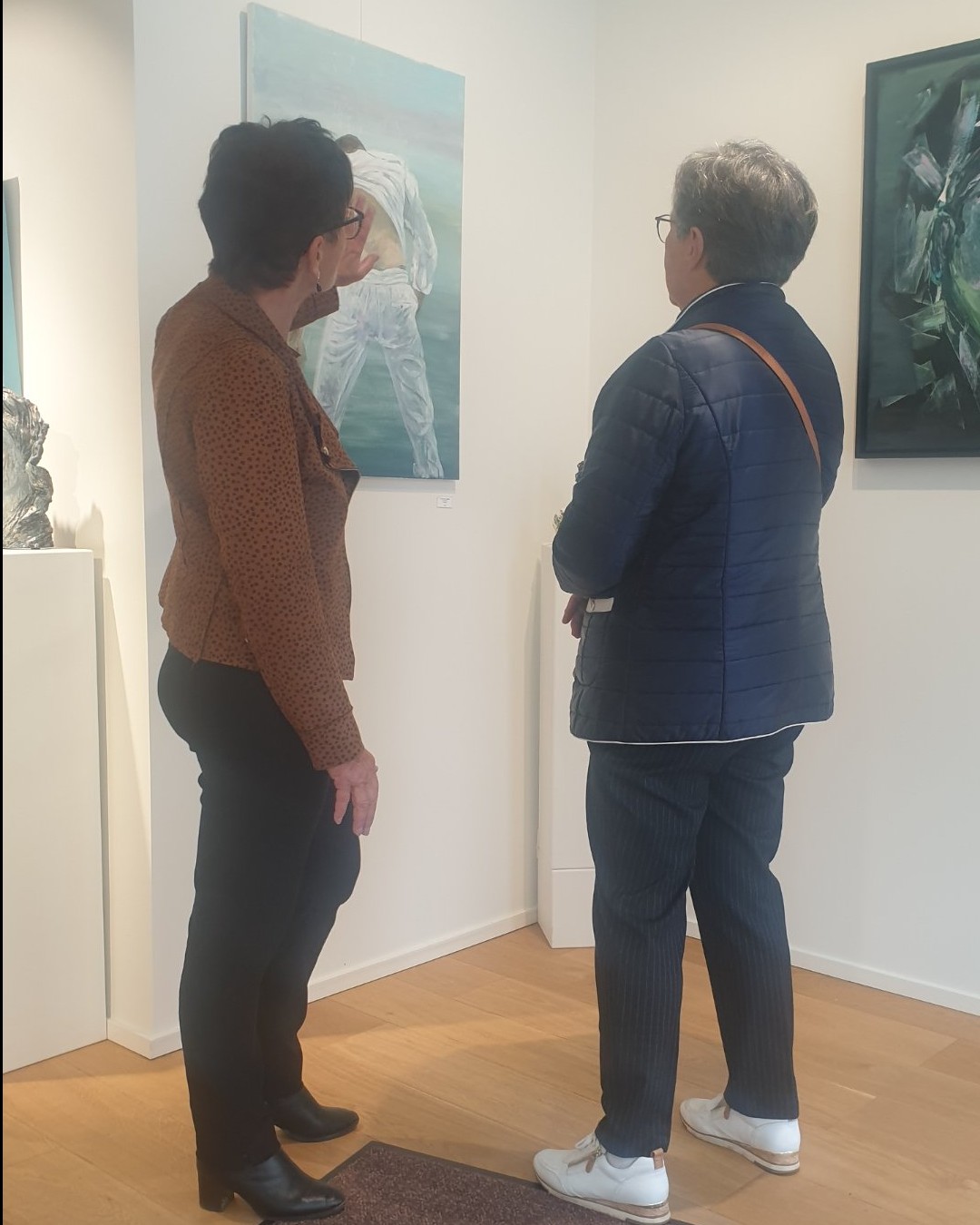L'artiste Sylviane Gaussin (veste marron à motifs) en plein échange avec un visiteur devant sa toile « Homme en suspension dans l'eau ». Ce moment d'échange pris sur le vif par Jérôme Selosse témoigne de la proximité entre l'artiste et le public, au cœur de son exposition conjointe avec la peintre Dalya Mesulam à la Bruno Matthys Gallery à Woluwe-Saint-Pierre (Bruxelles).
Site officiel de Sylviane Gaussin : https://www.sylviane-gaussin.be/WP2/
Galerie Bruno Matthys : https://brunomatthys.art/artist/sylviane-gaussin/
Détails de l'événement Dropmuse : https://dropmuse.art/evenement/sylviane-gaussin-et-dalya-mesulam-expo-peinture-et-sculpture-a-la-galerie-bruno-matthys-gallery-wolu
À découvrir aussi : https://www.instagram.com/simplydalya/

Photographie — Sylviane Gaussin et Dalya Mesulam - Expo peinture et sculpture à la galerie Bruno Matthys Gallery (Woluwe), Woluwe-Saint-Pierre