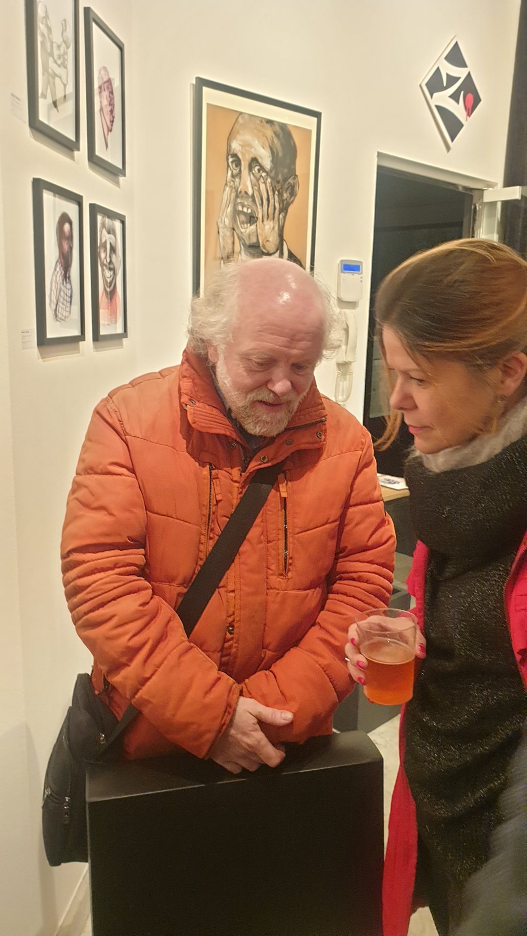 Le peintre et graveur Anastasio Marquez, en doudoune orange, au vernissage de « The Working Dead » chez Zaza from Brussels.

Le regard baissé, attentif, Anastasio Marquez prend le temps de regarder. Derrière lui, au mur, une grande tête de Renier Semidey aux mains plaquées sur les joues. Artiste de Huy, connu pour ses monotypes et ses gravures, il était au vernissage aux côtés du peintre Boris Mestchersky, lui aussi installé à Huy.

« The Working Dead » de Renier Semidey, jusqu'au 15 novembre 2026 chez Zaza from Brussels, rue Blaes 122, 1000 Bruxelles (Marolles). Le mercredi de 11h à 18h, du jeudi au dimanche de 11h à 19h. Entrée libre.

Voir les liens utiles en bas de la description.

🔗 Pour aller plus loin et soutenir l'art local :
L'exposition « The Working Dead » de Renier Semidey : https://dropmuse.art/evenement/the-working-dead-renier-semidey-zazafrombrussels-bruxelles-a9c827
Le peintre Boris Mestchersky sur DROPMUSE : https://dropmuse.art/artiste/boris-mestchersky-peintre-plasticien-huy
La fiche acteur culturel de Zaza from Brussels : https://dropmuse.art/acteur-culturel/zazafrombrussels
Le site de la galerie : https://zazafrombrussels.com/
Suivre la galerie sur Instagram : https://www.instagram.com/zazafrombrussels/
La galerie sur Facebook : https://www.facebook.com/GalerieZazafromBrussels/
Retrouvez toute l'actualité culturelle sur DROPMUSE : https://dropmuse.art/