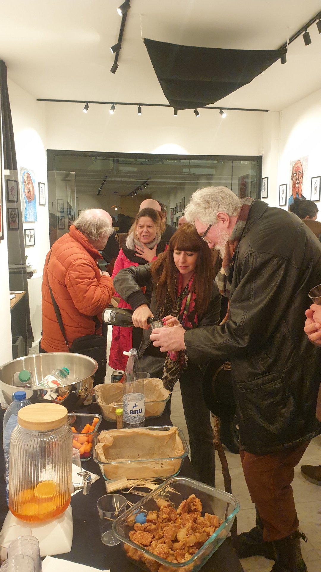 Le peintre Boris Mestchersky se fait servir un verre au vernissage de « The Working Dead », chez Zaza from Brussels, rue Blaes.

Un geste simple qui dit tout d'un vernissage : on se sert un verre, on discute, puis on retourne aux œuvres. Au fond, les portraits de Renier Semidey veillent sur la salle. L'univers lumineux de Boris Mestchersky tranche avec les figures grinçantes de « The Working Dead », et c'est tout le plaisir de ces rencontres entre artistes.

« The Working Dead » de Renier Semidey, jusqu'au 15 novembre 2026 chez Zaza from Brussels, rue Blaes 122, 1000 Bruxelles (Marolles). Le mercredi de 11h à 18h, du jeudi au dimanche de 11h à 19h. Entrée libre.

Voir les liens utiles en bas de la description.

🔗 Pour aller plus loin et soutenir l'art local :
Le peintre Boris Mestchersky sur DROPMUSE : https://dropmuse.art/artiste/boris-mestchersky-peintre-plasticien-huy
L'exposition « The Working Dead » de Renier Semidey : https://dropmuse.art/evenement/the-working-dead-renier-semidey-zazafrombrussels-bruxelles-a9c827
La fiche acteur culturel de Zaza from Brussels : https://dropmuse.art/acteur-culturel/zazafrombrussels
Le site de la galerie : https://zazafrombrussels.com/
Suivre la galerie sur Instagram : https://www.instagram.com/zazafrombrussels/
La galerie sur Facebook : https://www.facebook.com/GalerieZazafromBrussels/
Retrouvez toute l'actualité culturelle sur DROPMUSE : https://dropmuse.art/