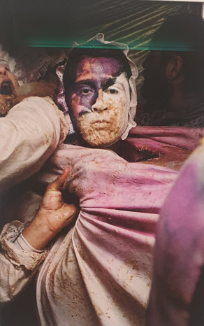 Portrait d'un artiste au visage peint en rose et pourpre, entouré de matériaux et d'outils de création, capturé par le photographe bruxellois Jérôme Selosse lors de l'exposition Haute Nuit (IESLP) à Bruxelles.
