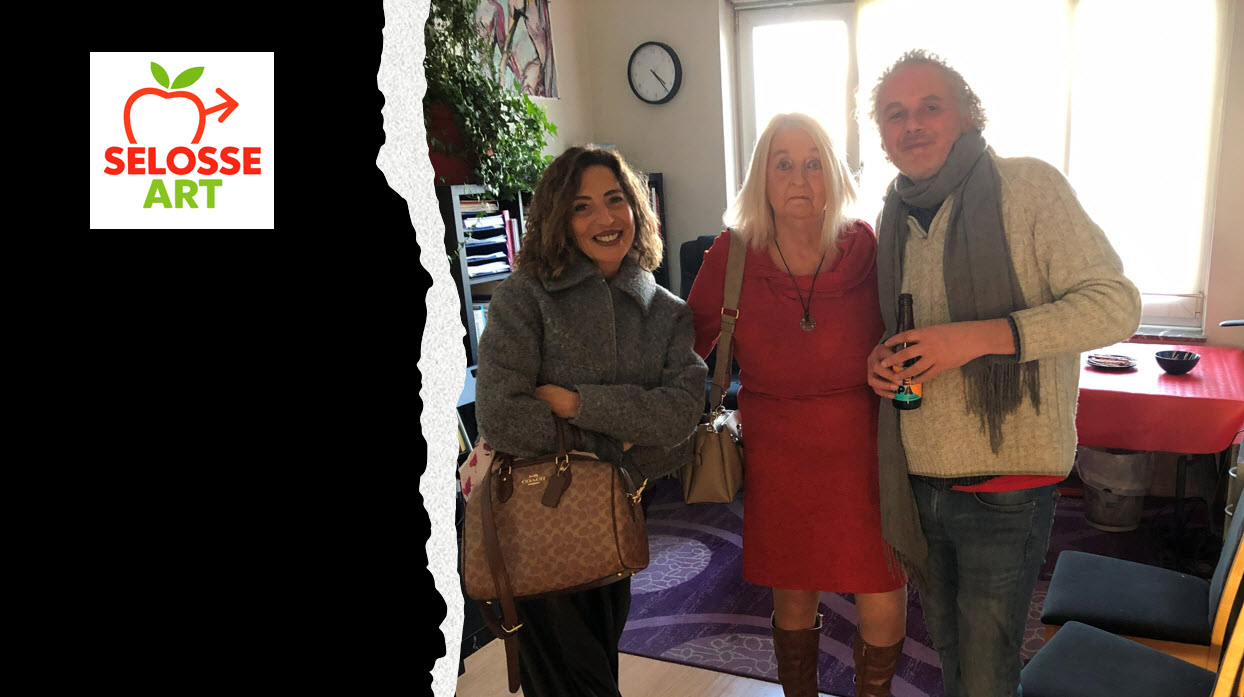 Photographie documentaire montrant trois personnes souriantes dans un intérieur lumineux avec logo Selosse Art visible, plantes vertes et décoration artistique en arrière-plan.