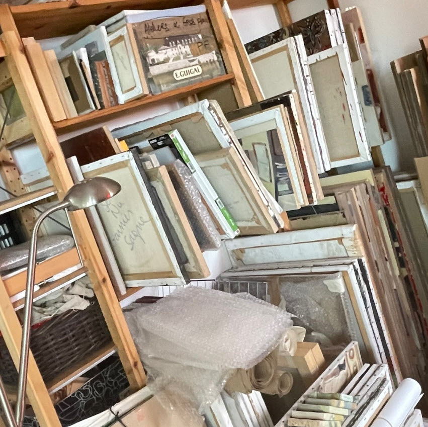 Vue plongeante sur l'atelier de l'artiste plasticienne Isabelle Garnier Sagne montrant des étagères en bois remplie de cadres, toiles, planches et matériaux artistiques variés, avec une lampe de travail et des rouleaux de peinture.
 Atelier de l'artiste plasticienne Isabelle Garnier Sagne - peintre à Montreuil (France)

Site internet de l'artiste: http://garniersagne.com/