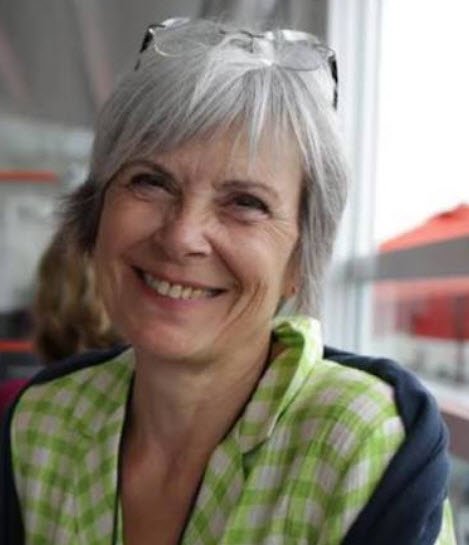 Portrait souriant d'Isabelle Fagot, artiste peintre et plasticienne, vêtue d'une veste verte et noire, lunettes de soleil relevées sur la tête.

Portrait photographique d'Isabelle Fagot, peintre et plasticienne Liège