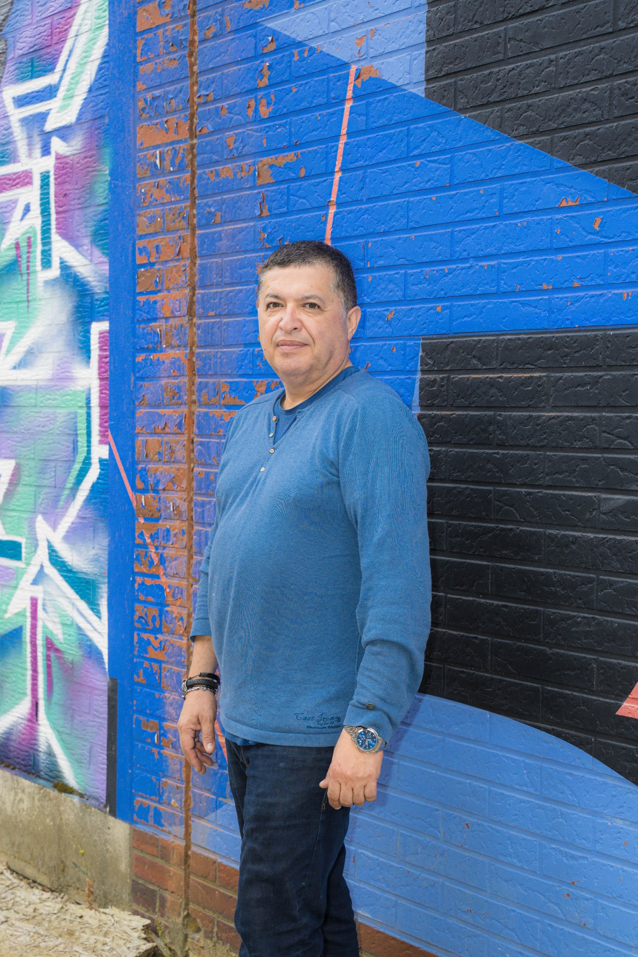 Portrait de l'artiste belgo-chilien Caliban Ramirez devant un mur peint en bleu à UR Square, Ixelles. Artiste belgo-chilien né à Santiago en 1967, Caliban Ramirez explore la mémoire, l'exil et la résilience par la peinture, la gravure, le papier artisanal et l'installation, nourri des mythologies du sud du Chili. À découvrir à UR Square (étape n°16), 227 avenue de la Couronne, le vendredi 6 novembre de 18h à 22h, puis le samedi 7 et le dimanche 8 de 11h à 18h, pendant le Parcours d'Artistes d'Ixelles 2026.

Crédit photo - Gabrielle Liefooghe pour le Parcours d'Artistes d'Ixelles 2026 @googoo.eyes__ @ici_vaisseau_mere

Crédits & Liens :
Instagram : https://www.instagram.com/calibanramirez/
Fiche de l'événement (Dropmuse) : https://dropmuse.art/evenement/parcours-dartistes-dixelles-2026-ateliers-ouverts-creation-locale-ixelles-ixelles-bruxelles
Organisation : Vaisseau Mère — https://www.instagram.com/ici_vaisseau_mere/
Photographe Gabrielle Liefooghe : https://www.gabrielleliefooghe.com/ — https://www.instagram.com/googoo.eyes__/

Kult Ixelles sur DROPMUSE :
https://dropmuse.art/acteur-culturel/kult-ixelles-institution-residence-ixelles