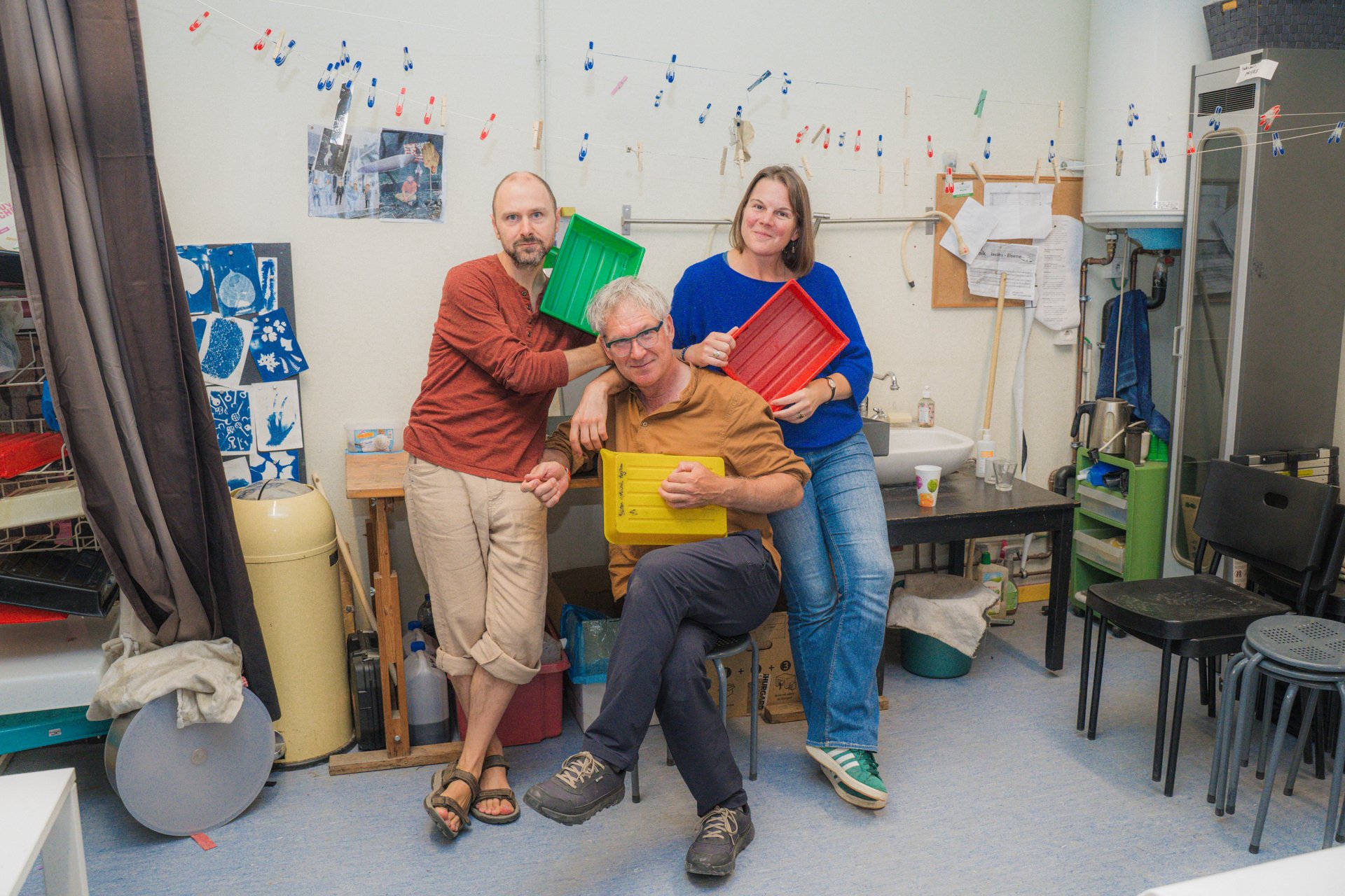 Les photographes de Co'lab posent avec leurs boîtes de papier photo colorées dans leur labo de UR Square. Laboratoire photo partagé fondé par Myriam Andries, Sander de Wilde et Nicolas Andry, rejoints par Déborah Kempczynski, Co'lab explore les procédés artisanaux et écoresponsables comme la cyanotypie et les chimies naturelles. À découvrir à UR Square (étape n°16), 227 avenue de la Couronne, le vendredi 6 novembre de 18h à 22h, puis le samedi 7 et le dimanche 8 de 11h à 18h, pendant le Parcours d'Artistes d'Ixelles 2026.

Crédit photo - Gabrielle Liefooghe pour le Parcours d'Artistes d'Ixelles 2026 @googoo.eyes__ @ici_vaisseau_mere

Crédits & Liens :
Site : https://colab.collectifs.net
Fiche de l'événement (Dropmuse) : https://dropmuse.art/evenement/parcours-dartistes-dixelles-2026-ateliers-ouverts-creation-locale-ixelles-ixelles-bruxelles
Organisation : Vaisseau Mère — https://www.instagram.com/ici_vaisseau_mere/
Photographe Gabrielle Liefooghe : https://www.gabrielleliefooghe.com/ — https://www.instagram.com/googoo.eyes__/

Kult Ixelles sur DROPMUSE :
https://dropmuse.art/acteur-culturel/kult-ixelles-institution-residence-ixelles