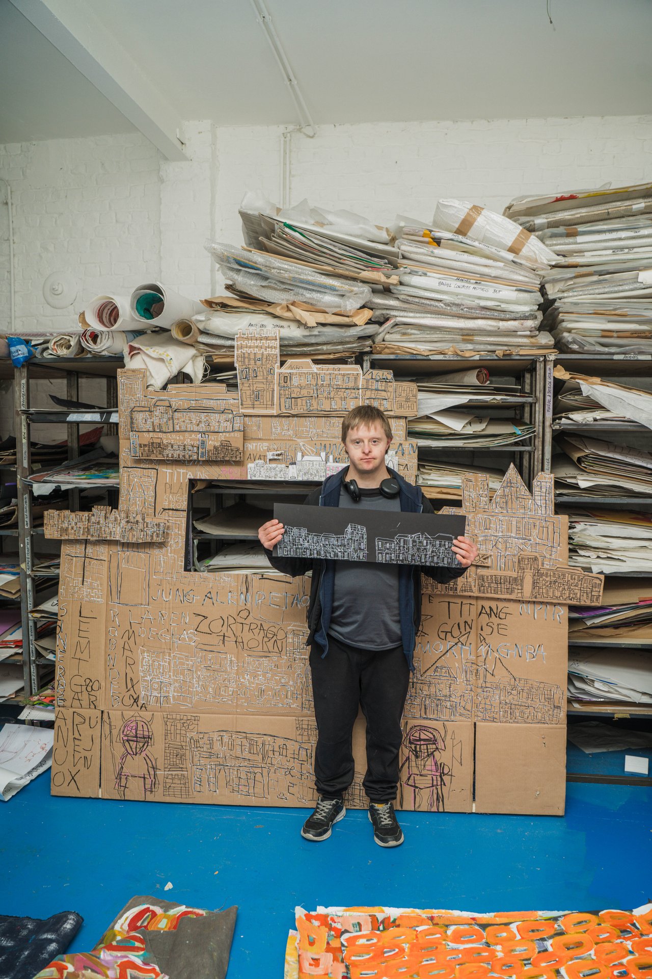 Un artiste du Créahmbxl pose devant une grande construction en carton dessinée, au milieu des archives de l'atelier. Laboratoire d'expérimentation artistique pour des artistes en situation de handicap mental, le Créahmbxl ouvre ses ateliers et présente une exposition collective de dix artistes. À découvrir au Créahmbxl (étape n°18), 224 avenue de la Couronne, le samedi 7 et le dimanche 8 novembre, de 11h à 18h, pendant le Parcours d'Artistes d'Ixelles 2026.

Crédit photo - Gabrielle Liefooghe pour le Parcours d'Artistes d'Ixelles 2026 @googoo.eyes__ @ici_vaisseau_mere

Crédits & Liens :
Site : https://creahmbxl.be
Fiche de l'événement (Dropmuse) : https://dropmuse.art/evenement/parcours-dartistes-dixelles-2026-ateliers-ouverts-creation-locale-ixelles-ixelles-bruxelles
Organisation : Vaisseau Mère — https://www.instagram.com/ici_vaisseau_mere/
Photographe Gabrielle Liefooghe : https://www.gabrielleliefooghe.com/ — https://www.instagram.com/googoo.eyes__/

Kult Ixelles sur DROPMUSE :
https://dropmuse.art/acteur-culturel/kult-ixelles-institution-residence-ixelles