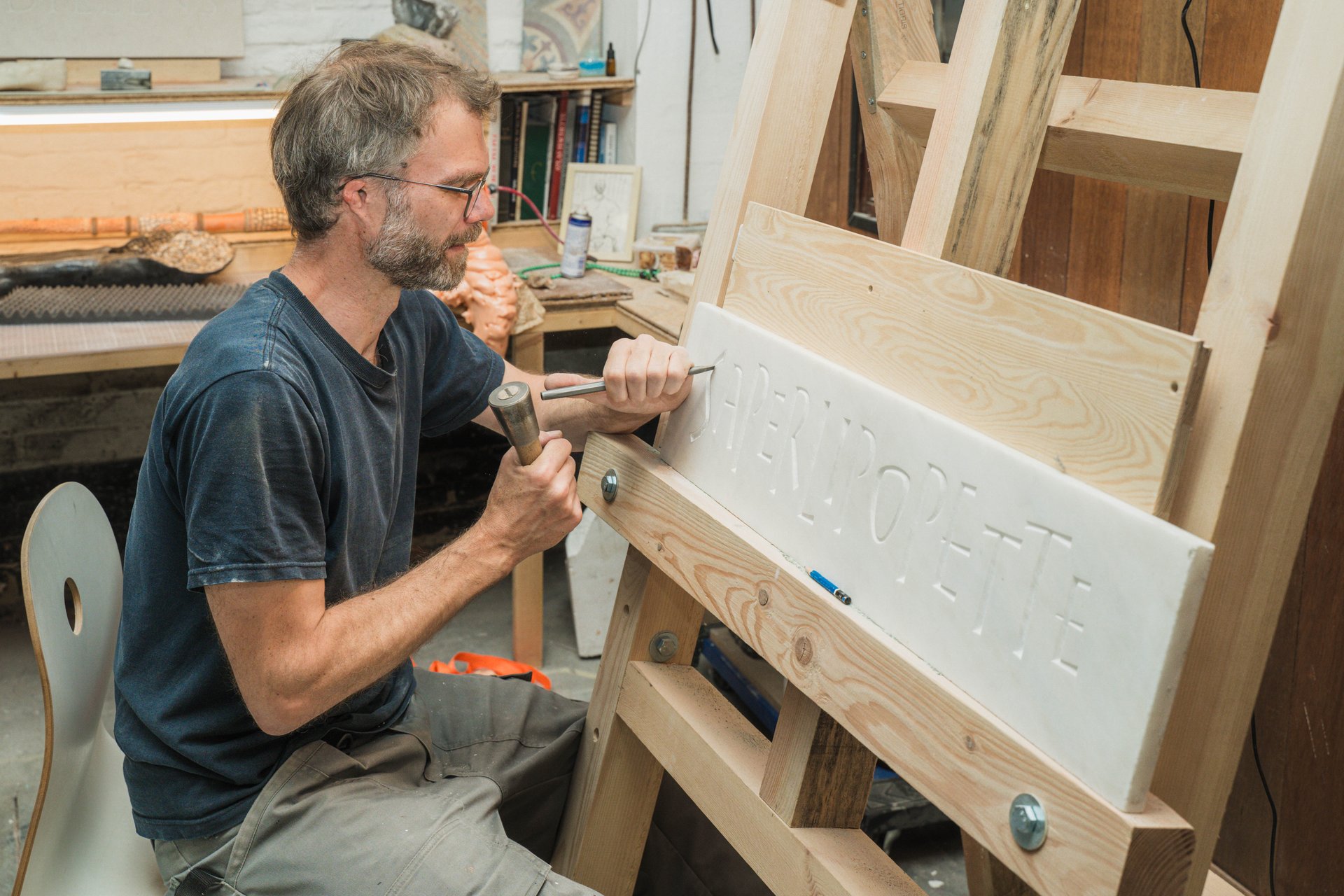 Gros plan sur le geste du sculpteur de CTRLZ qui grave une inscription dans une plaque de pierre blanche. Atelier partagé et lieu de résidence, CTRLZ accueille cette année Roman Balthazart, Xavier Daive, Reese De L'arbre, Caroline El Khoury, Kimia Nasirian, Olivia Perce et Luka Vieuville Barrier ; ses expositions se regardent aussi depuis le trottoir. À découvrir chez CTRLZ (étape n°22), 43 rue Dillens, le vendredi 6 novembre de 18h à 22h, puis le samedi 7 et le dimanche 8 de 11h à 18h, pendant le Parcours d'Artistes d'Ixelles 2026.

Crédit photo - Gabrielle Liefooghe pour le Parcours d'Artistes d'Ixelles 2026 @googoo.eyes__ @ici_vaisseau_mere

Crédits & Liens :
Instagram : https://www.instagram.com/espacectrlz/
Fiche de l'événement (Dropmuse) : https://dropmuse.art/evenement/parcours-dartistes-dixelles-2026-ateliers-ouverts-creation-locale-ixelles-ixelles-bruxelles
Organisation : Vaisseau Mère — https://www.instagram.com/ici_vaisseau_mere/
Photographe Gabrielle Liefooghe : https://www.gabrielleliefooghe.com/ — https://www.instagram.com/googoo.eyes__/

Kult Ixelles sur DROPMUSE :
https://dropmuse.art/acteur-culturel/kult-ixelles-institution-residence-ixelles