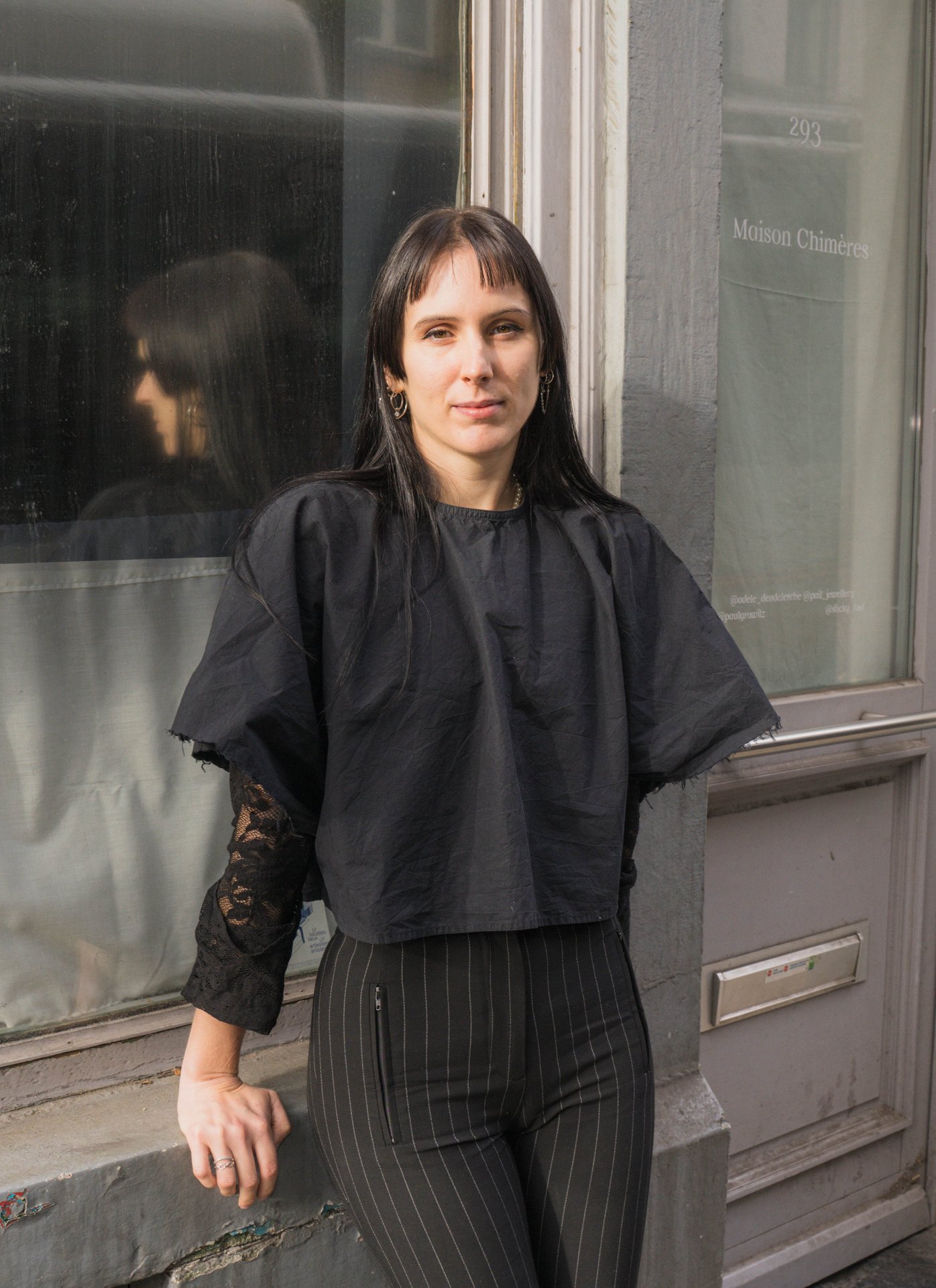 Portrait d'une artiste de la Maison Chimères devant la vitrine de l'atelier, chaussée d'Ixelles. Atelier collectif ouvert en 2024, la Maison Chimères réunit Adèle Dendaletche (chaussures expérimentales), Emil MBR (illustration), Pail Jewellery (bijoux), BR00KLYN B3B3 (textile et graphisme), Sticky (arts visuels et design culinaire), Laura Méresse (céramique) et Maigre Serpent (graphisme), avec un marché de créateurs. À découvrir à la Maison Chimères (étape n°32), 293 chaussée d'Ixelles, le vendredi 6 novembre de 18h à 22h, puis le samedi 7 et le dimanche 8 de 11h à 18h, pendant le Parcours d'Artistes d'Ixelles 2026.

Crédit photo - Gabrielle Liefooghe pour le Parcours d'Artistes d'Ixelles 2026 @googoo.eyes__ @ici_vaisseau_mere

Crédits & Liens :
Fiche de l'événement (Dropmuse) : https://dropmuse.art/evenement/parcours-dartistes-dixelles-2026-ateliers-ouverts-creation-locale-ixelles-ixelles-bruxelles
Organisation : Vaisseau Mère — https://www.instagram.com/ici_vaisseau_mere/
Photographe Gabrielle Liefooghe : https://www.gabrielleliefooghe.com/ — https://www.instagram.com/googoo.eyes__/

Kult Ixelles sur DROPMUSE :
https://dropmuse.art/acteur-culturel/kult-ixelles-institution-residence-ixelles