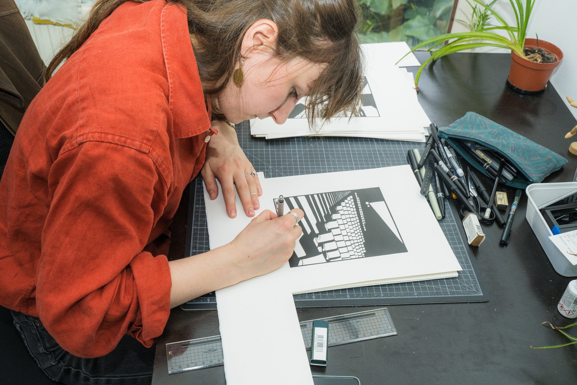 Penchée sur sa table, l'autrice de bande dessinée Manon Barichard encre une planche en noir et blanc. Autrice et illustratrice de bande dessinée diplômée de l'ESA Saint-Luc, Manon Barichard montre des planches originales et des illustrations sérigraphiées nées à l'Atelier Serpentin. À découvrir à l'Atelier 202 (étape n°24), 202 rue Gray, le vendredi 6 novembre de 18h à 22h, puis le samedi 7 et le dimanche 8 de 11h à 18h, pendant le Parcours d'Artistes d'Ixelles 2026.

Crédit photo - Gabrielle Liefooghe pour le Parcours d'Artistes d'Ixelles 2026 @googoo.eyes__ @ici_vaisseau_mere

Crédits & Liens :
Instagram : https://www.instagram.com/manon_barichard/
Fiche de l'événement (Dropmuse) : https://dropmuse.art/evenement/parcours-dartistes-dixelles-2026-ateliers-ouverts-creation-locale-ixelles-ixelles-bruxelles
Organisation : Vaisseau Mère — https://www.instagram.com/ici_vaisseau_mere/
Photographe Gabrielle Liefooghe : https://www.gabrielleliefooghe.com/ — https://www.instagram.com/googoo.eyes__/

Kult Ixelles sur DROPMUSE :
https://dropmuse.art/acteur-culturel/kult-ixelles-institution-residence-ixelles