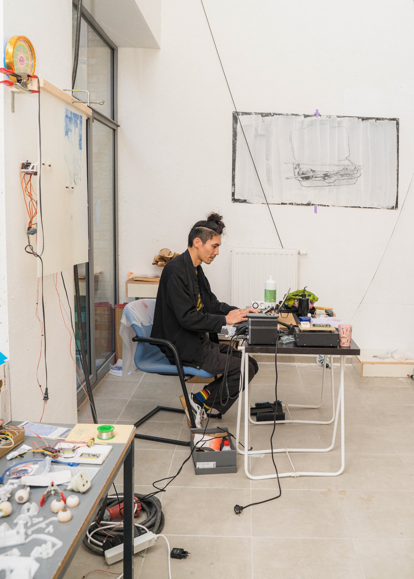 Thy Nguyễn Truong Minh au travail à son poste, entouré de câbles et de machines, aux KULT XL Ateliers. Artiste et codeur·euse vietnamo-belge, Thy Nguyễn Truong Minh construit des « machines lentes » qui mêlent art mécanique, technologies obsolètes et récits fragmentés. À découvrir aux KULT XL Ateliers 3 (étape n°38), 21a rue Wiertz, le vendredi 6 novembre de 15h à 19h, puis le samedi 7 et le dimanche 8 de 14h à 18h, pendant le Parcours d'Artistes d'Ixelles 2026.

Crédit photo - Gabrielle Liefooghe pour le Parcours d'Artistes d'Ixelles 2026 @googoo.eyes__ @ici_vaisseau_mere

Crédits & Liens :
Instagram : https://www.instagram.com/thytruongminh/
Fiche de l'événement (Dropmuse) : https://dropmuse.art/evenement/parcours-dartistes-dixelles-2026-ateliers-ouverts-creation-locale-ixelles-ixelles-bruxelles
Organisation : Vaisseau Mère — https://www.instagram.com/ici_vaisseau_mere/
Photographe Gabrielle Liefooghe : https://www.gabrielleliefooghe.com/ — https://www.instagram.com/googoo.eyes__/

Kult Ixelles sur DROPMUSE :
https://dropmuse.art/acteur-culturel/kult-ixelles-institution-residence-ixelles