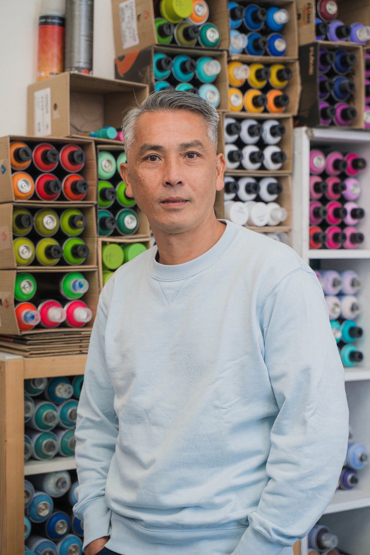 Portrait du graffeur Orkez devant un mur de bombes de peinture de toutes les couleurs, à UR Square. Bruxellois d'origine vietnamienne, Orkez pratique un graffiti précis et épuré, nourri d'architecture urbaine et d'esthétique typographique. À découvrir à UR Square (étape n°16), 227 avenue de la Couronne, le vendredi 6 novembre de 18h à 22h, puis le samedi 7 et le dimanche 8 de 11h à 18h, pendant le Parcours d'Artistes d'Ixelles 2026.

Crédit photo - Gabrielle Liefooghe pour le Parcours d'Artistes d'Ixelles 2026 @googoo.eyes__ @ici_vaisseau_mere

Crédits & Liens :
Instagram : https://www.instagram.com/orkez.insta/
Fiche de l'événement (Dropmuse) : https://dropmuse.art/evenement/parcours-dartistes-dixelles-2026-ateliers-ouverts-creation-locale-ixelles-ixelles-bruxelles
Organisation : Vaisseau Mère — https://www.instagram.com/ici_vaisseau_mere/
Photographe Gabrielle Liefooghe : https://www.gabrielleliefooghe.com/ — https://www.instagram.com/googoo.eyes__/

Kult Ixelles sur DROPMUSE :
https://dropmuse.art/acteur-culturel/kult-ixelles-institution-residence-ixelles