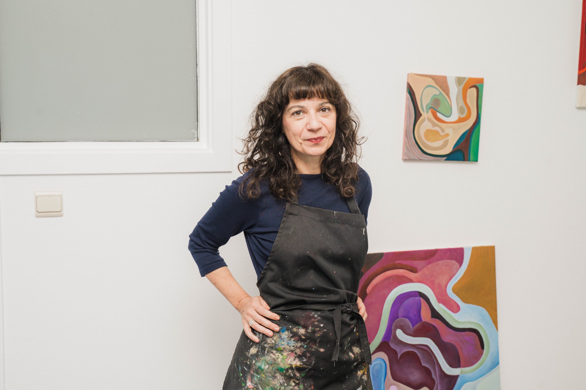 Zeta Tsermou, main sur la hanche, devant ses peintures aux courbes colorées dans son atelier rue Dautzenberg. Par la peinture, le dessin, la sculpture et la vidéo, Zeta Tsermou fragmente et recompose le corps pour explorer le désir et l'identité féminine. À découvrir à l'étape n°25 du parcours, 44 rue Dautzenberg, le vendredi 6 novembre de 18h à 22h, puis le samedi 7 et le dimanche 8 de 11h à 18h, pendant le Parcours d'Artistes d'Ixelles 2026.

Crédit photo - Gabrielle Liefooghe pour le Parcours d'Artistes d'Ixelles 2026 @googoo.eyes__ @ici_vaisseau_mere

Crédits & Liens :
Instagram : https://www.instagram.com/zetatsermou/
Site : https://zetatsermou.com
Fiche de l'événement (Dropmuse) : https://dropmuse.art/evenement/parcours-dartistes-dixelles-2026-ateliers-ouverts-creation-locale-ixelles-ixelles-bruxelles
Organisation : Vaisseau Mère — https://www.instagram.com/ici_vaisseau_mere/
Photographe Gabrielle Liefooghe : https://www.gabrielleliefooghe.com/ — https://www.instagram.com/googoo.eyes__/

Kult Ixelles sur DROPMUSE :
https://dropmuse.art/acteur-culturel/kult-ixelles-institution-residence-ixelles