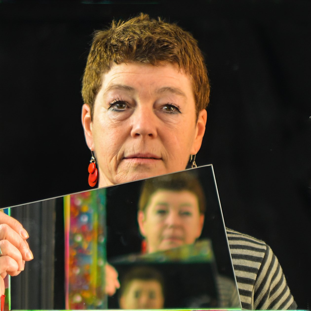 Aut-portrait et reflet multiple dans un miroir sur fond noir.